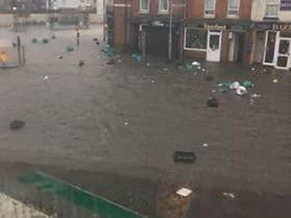 Bin bags and recycling boxes float down the street on floodwater in St Leonards Road.