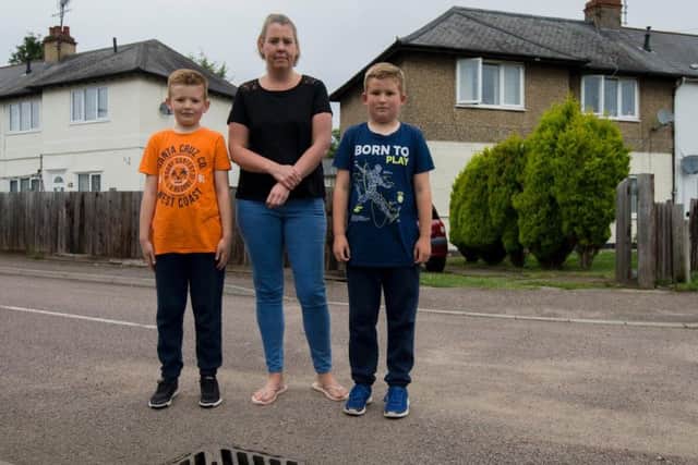 Henry, Claire, and Freddie Buswell were using their buckets and spades in the thunder and lightening - with the help of 18 neighbours in the cul-de-sac - to clear the water, which was swirling around the drain (pictured).