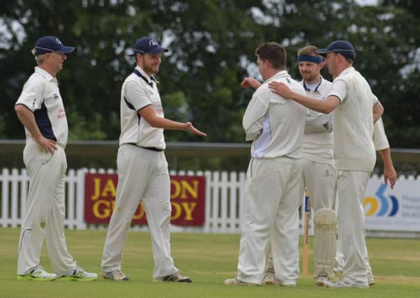 Brixworth IIs' players celebrate a wicket in their match with Irchester (Pictures: Dave Ikin)