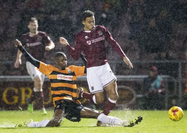 Hakeem Odoffin makes a sliding tackle on the Cobblers' Dominic Calvert-Lewin at Sixfields in Januaey, 2016. It was the 17-year-old Barnet defender's League debut