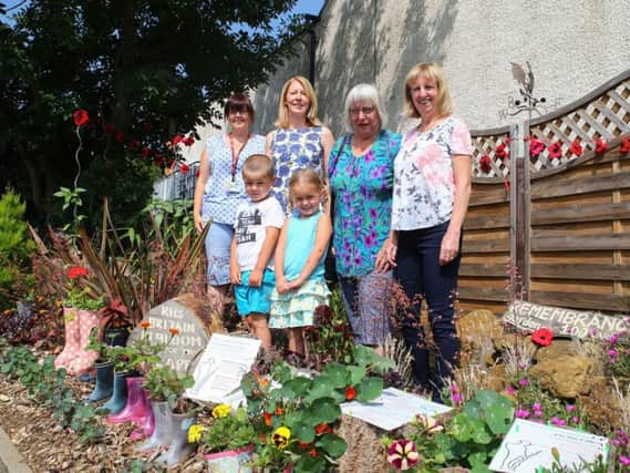 Four of the Cotton Land Girls, all members of Far Cotton Residents' Association, and two nursery pupils, pictured at their 'World War One Wellies' display on Towcester Road.