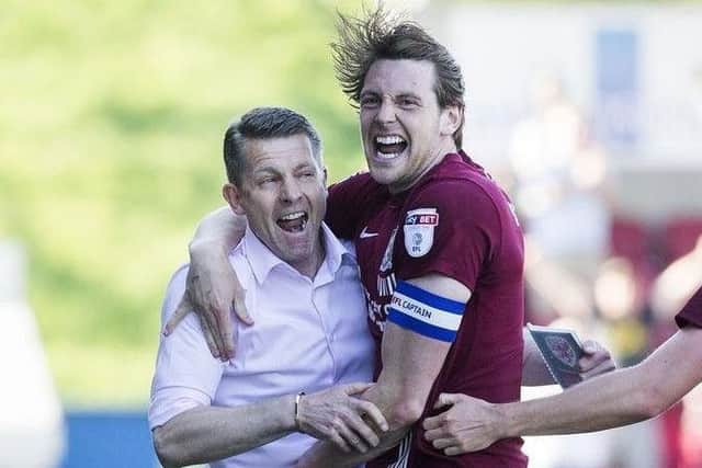 Cobblers boss Dean Austin and Ash Taylor celebrate a goal in last season's final day draw with Oldham Athletic