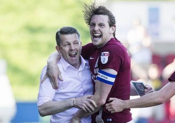 Cobblers boss Dean Austin and Ash Taylor celebrate a goal in last season's final day draw with Oldham Athletic