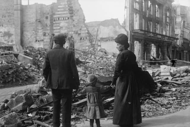 A refugee family returning to Amiens, looking at the ruins of a house, September 17, 1918.© IWM (Q 11341)