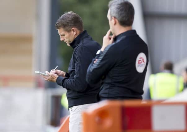 Dean Austin makes notes during his team's defeat at Morecambe on Tuesday (Picture: kirsty Edmonds)