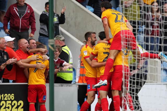 AT LAST: Cobblers celebrate Billy Waters' stoppage-time second at Colchester. Pictures: Sharon Lucey