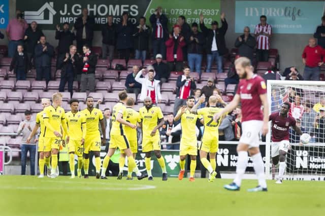 GRIM: Cheltenham players and fans celebrate while the Cobblers face up to the prospect of another defeat. Pictures: Kirsty Edmonds