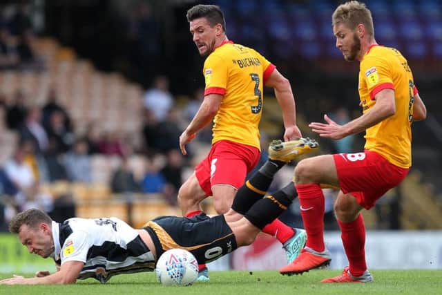Sam Foley (right) and David Buchanan tussle with Port Vale's Ricky Miller