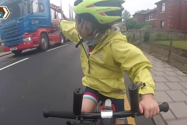 Four-year-old Rhoda Jones of Wellingborough gives the thumbs up to a lorry driver who passed her and her family safely while they were cycling