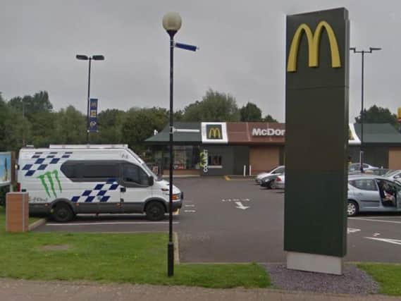 An employee at the Sixfields McDonald's was pictured appearing to spray a homeless man with a jet washer.