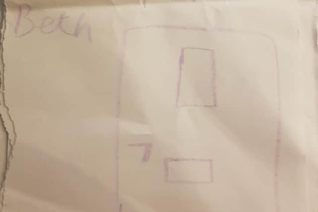 The picture drawn by Beth shows the serving hatch through which she can speak to her family.
