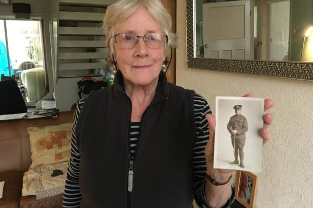 Rosemary Lane holds a postcard photograph of her father Reg Inwards