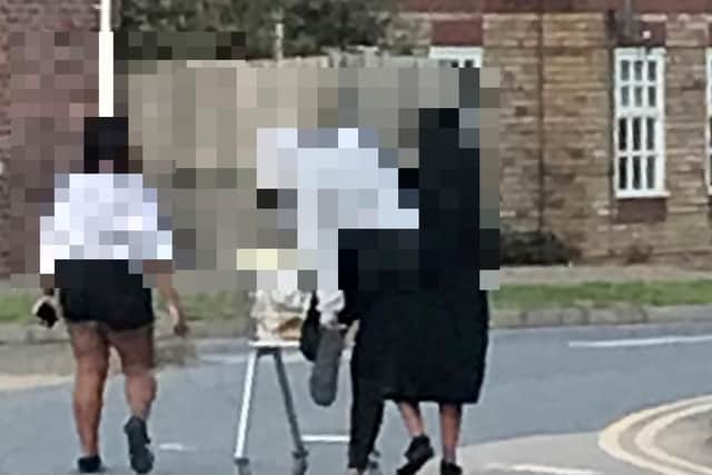 Students carrying a shopping trolley in Far Cotton.