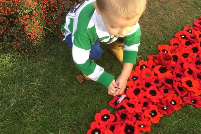 Luke Bullard placing a tribute to his great-great-great Uncle Henry