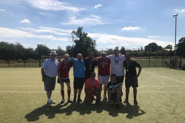 The winners of the football tournament proudly displaying their medals presented by Graham Baker (left) the owner of Butchers Pet Care.