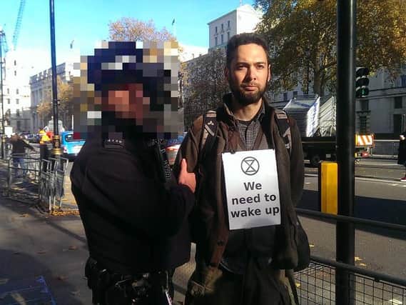 Northampton man Nick Cooper is led away by police after taking part in a climate change protest in London.