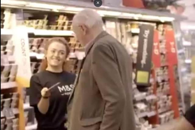 A dancer hands a customer his very own 100 food voucher.