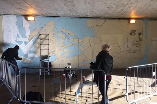 A street artist laid the first layers of a new mural for Emporium Way today.
