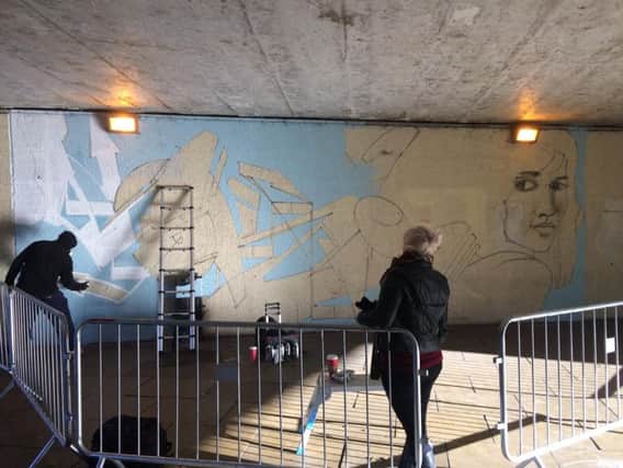 A street artist laid the first layers of a new mural for Emporium Way today.