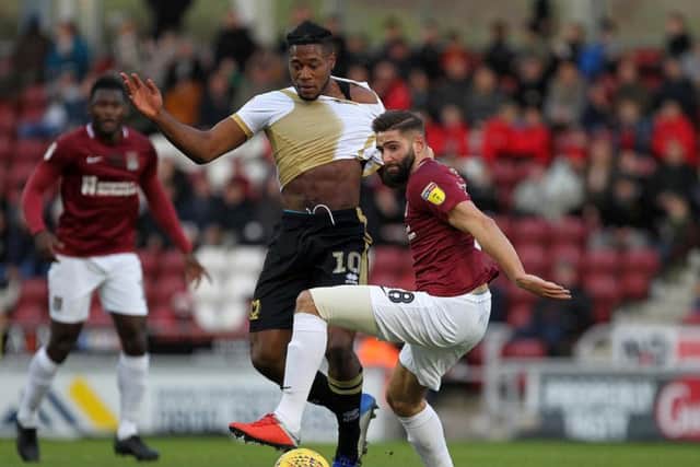 Jordan Turnbull tussles with Milton Keynes striker Chuks Aneke (Pictures: Sharon Lucey)