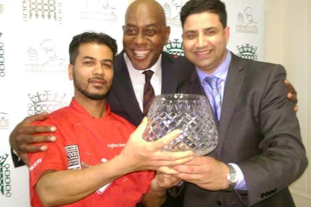 Naz Islam pictured being presented with the trophy by celebrity chef Ainsley Harriott and Saffron chef Bodrul Islam.
