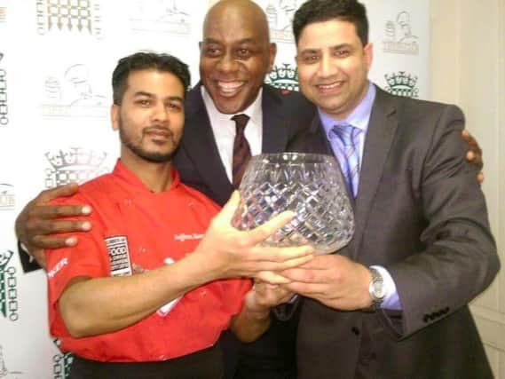 Naz Islam pictured being presented with the trophy by celebrity chef Ainsley Harriott and Saffron chef Bodrul Islam.