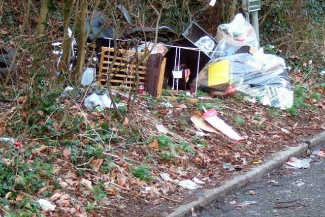 Chairs, a clothes horse and bags of rubbish lay strewn next to the layby.