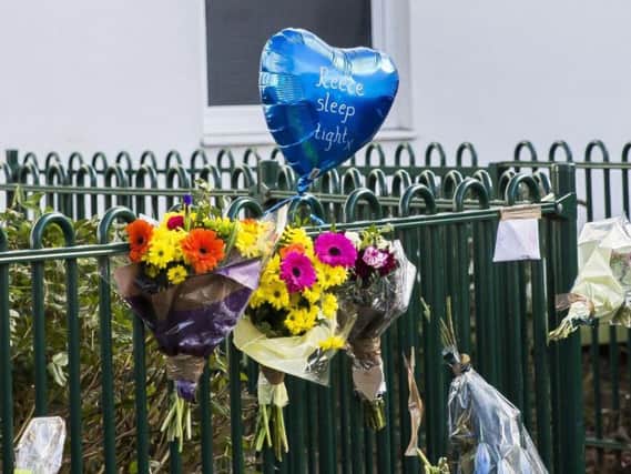Seven bunches of flowers and a blue heart-shaped balloon were left by the railings at the scene of the murder