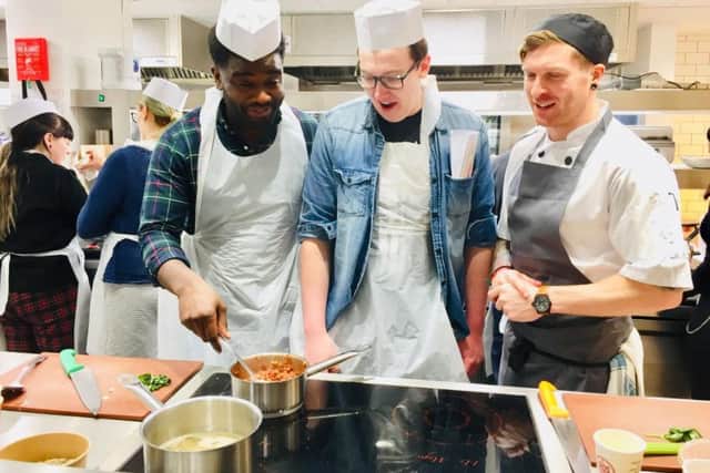 Pictured from left are students Alphonse Okamba and Tom Marshall with chef David Lively.