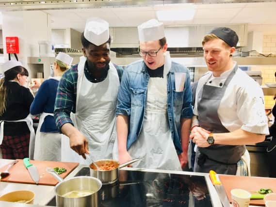 Pictured from left are students Alphonse Okamba and Tom Marshall with chef David Lively.