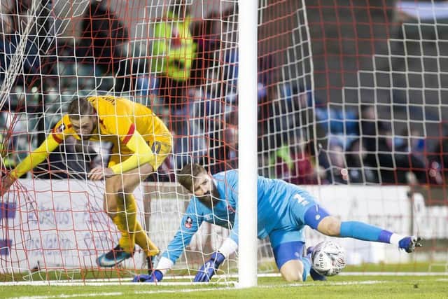 Former Cobblers striker Kevin van Veen collides with Lincoln goalkeeper Josh Vickers.