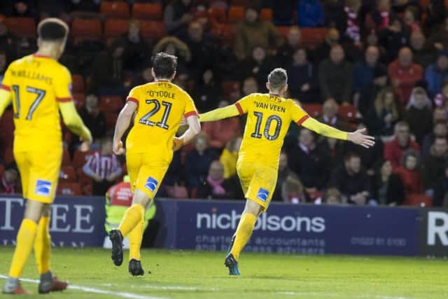 Van Veen wheels away in celebration at Sincil Bank.