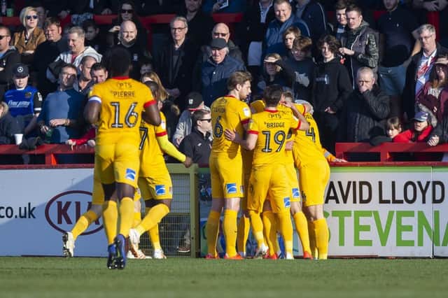 Joe Powell is mobbed by his team-mates after opening the scoring at Stevenage. Picture: Kirsty Edmonds