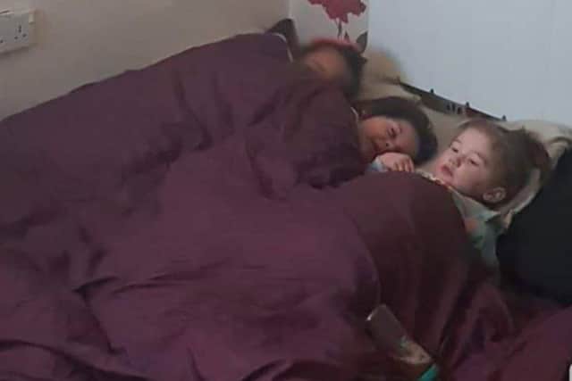 The little girls pictured tucked up in their bed in the living room while they wait for repair works to commence.