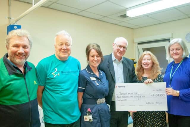 Catherine pictured handing over her cheque to teams at NGH and Bowel Cancer UK to help fund research.
