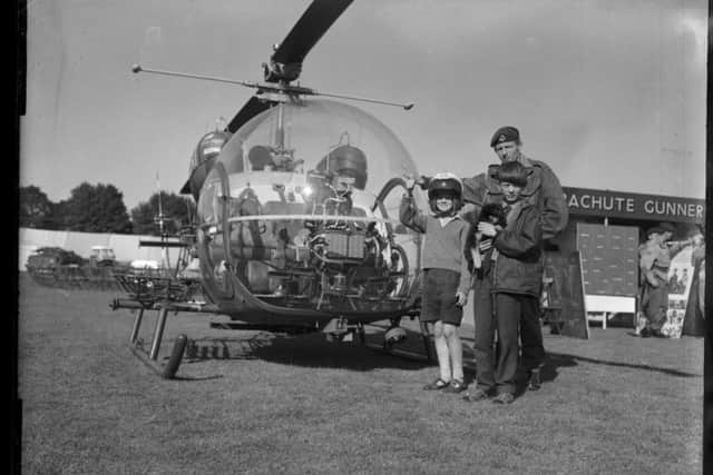 Two young pilots (and a puppy ) pose next to an army helicopter at the Northampton Show, August 5, 1966