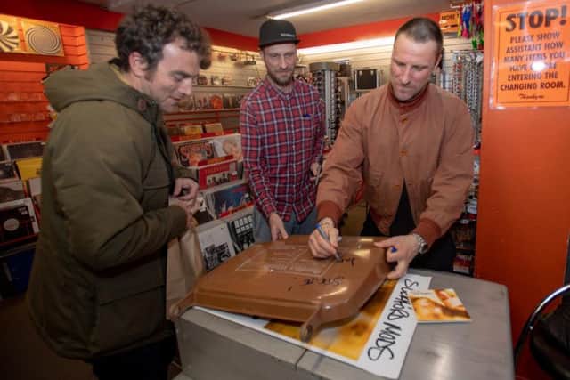 Sleaford Mods pictured signing a fan's bin lid.