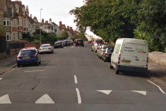A woman was robbed by two men on a moped while she was sat in her car.