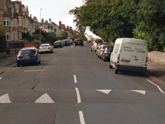 A woman was robbed by two men on a moped while she was sat in her car.