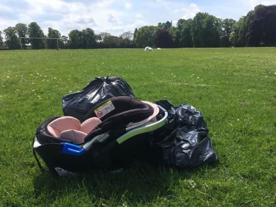 A car seat has been left behind amongst the rubbish in Dallington Park today.