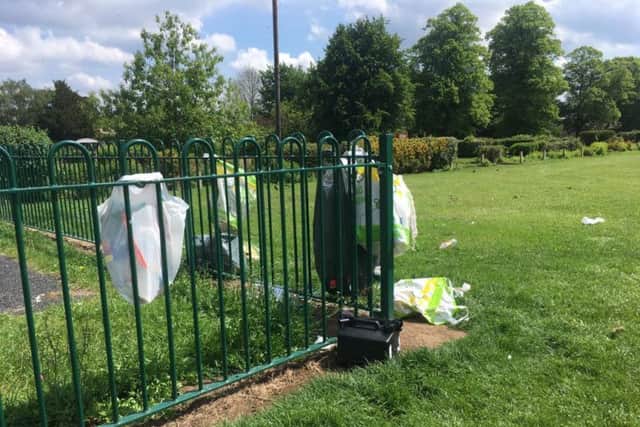 Some of the rubbish has been strewn across the railings next to the children's play area.