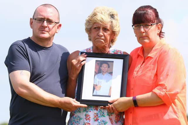 Stephen's family - brother Darrell, mum Ann and sister Tracey - with his portrait.