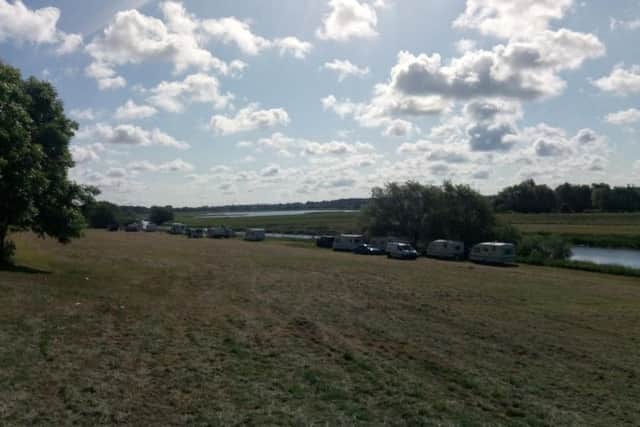 The four caravans and one camper van have been parked on the banks of the River Nene oppositethe Lakes business park