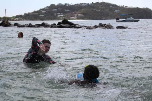 Millie Dorgan shows one of the children what to do with their arms in the water. Photo: Millie Dorgan