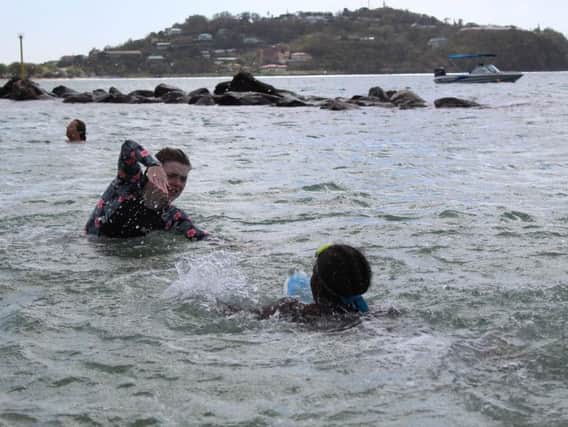 Millie Dorgan shows one of the children what to do with their arms in the water. Photo: Millie Dorgan