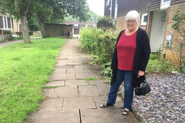 Dianne Finnie next to the uneven paving slabs between Tonmead Road and Mounts Court