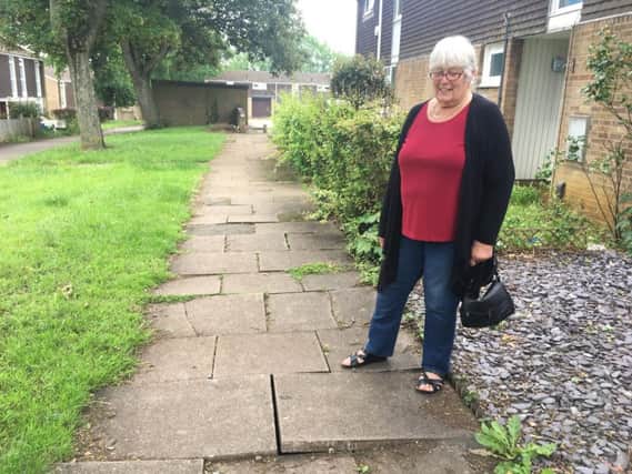 Dianne Finnie next to the uneven paving slabs between Tonmead Road and Mounts Court