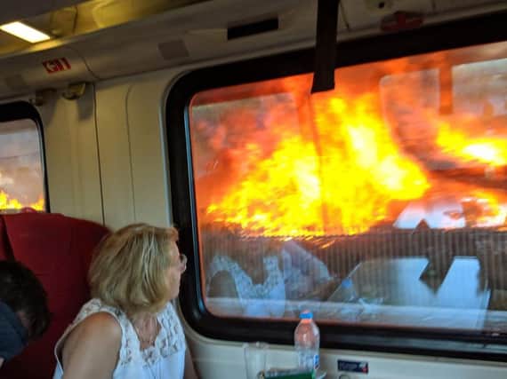 Passengers watched on as they travelled past the raging flames. Picture by Sarah Cole.