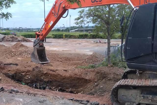 The picture appears to show former landfill being dug up.