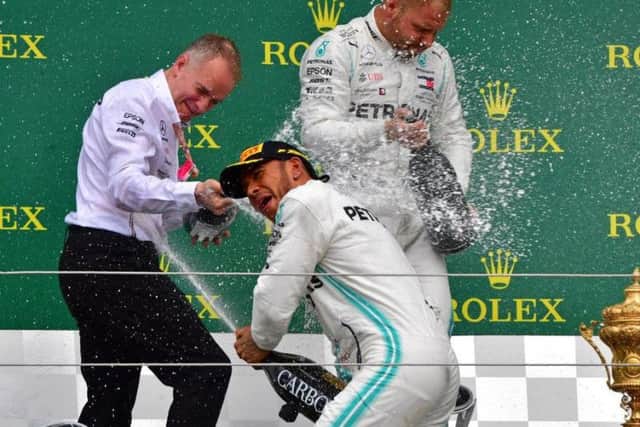 Lewis Hamilton celebrates in traditional style on the podium